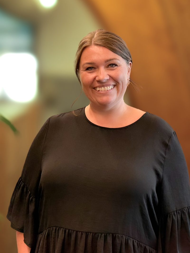 Malene fra supporten smiler på kontoret